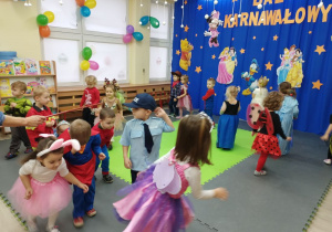 Dzieci przechodzą pod laską gimnastyczną w rytm muzyki